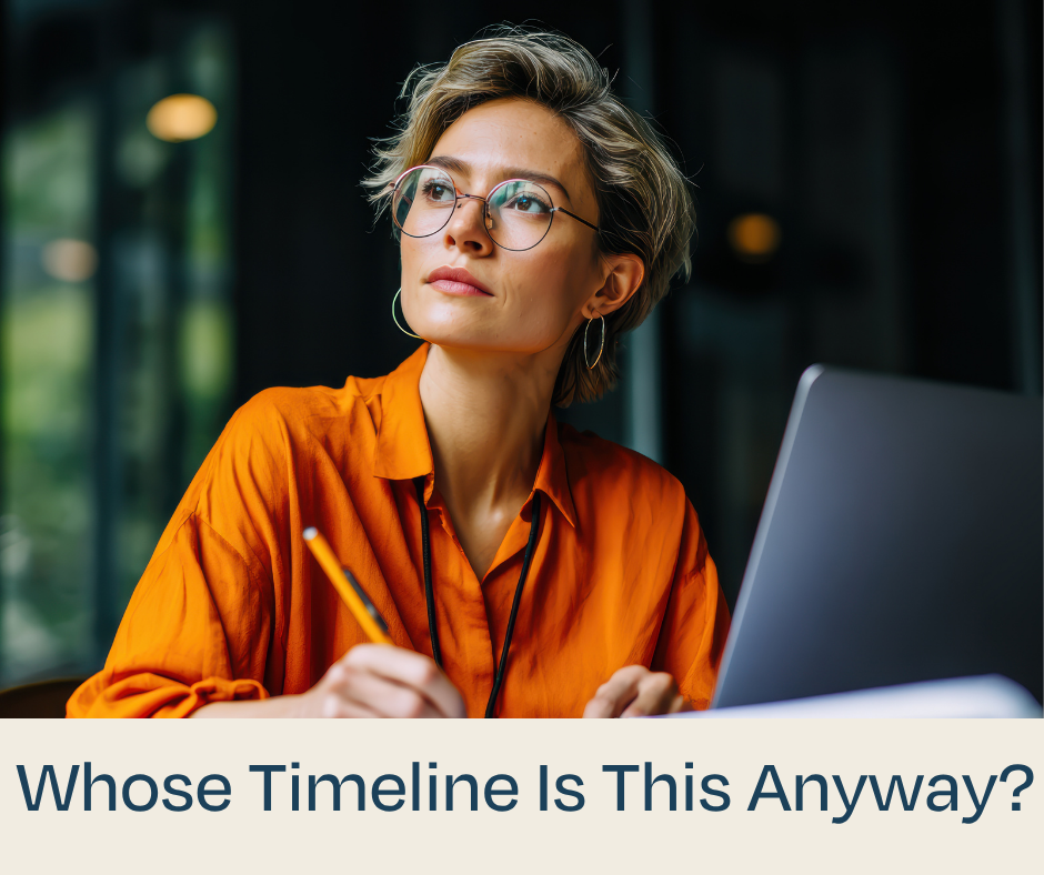 Woman thinking in a orange shirt with glasses on and a pen in her hand and computer in front of her.
